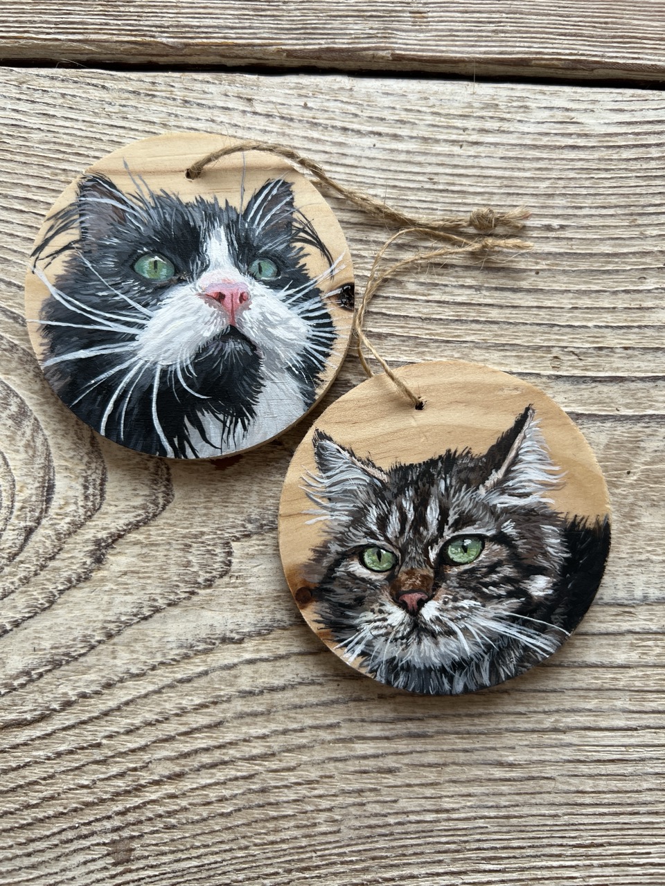 Deux portraits de chats peints à la main sur des rondelles de bois